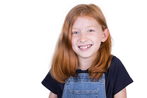 Eight-year-old redhead photographed against a white background.