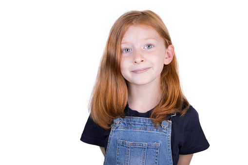 Eight year old girl with her red hair photographed against a white background.