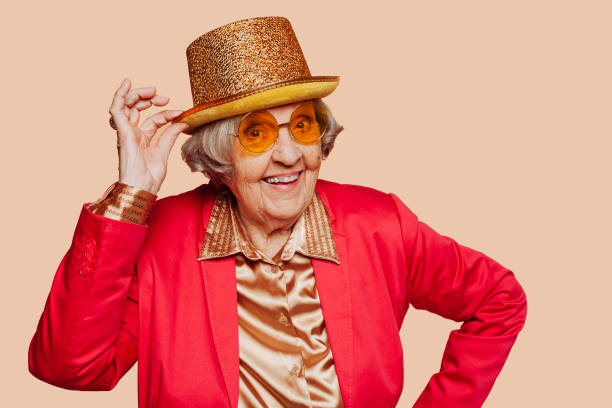 istock Funny stylish elderly grandmother posing with hat at studio 1412645066