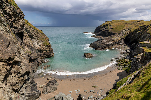 tintagel bay cornwall below the castle with clearing rain storm out to sea