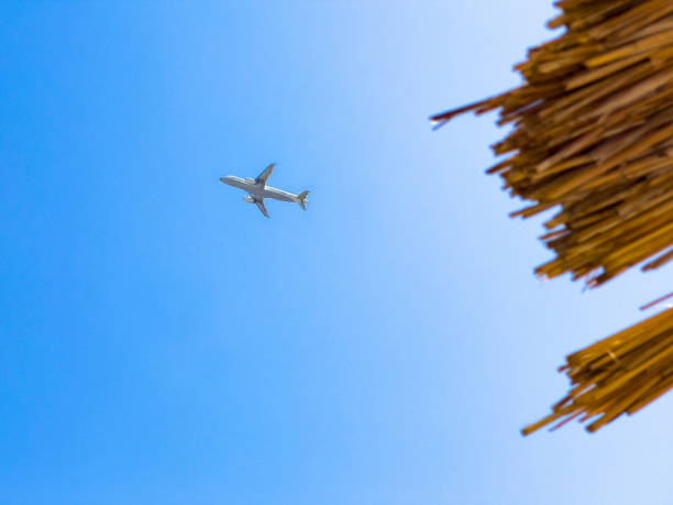 istock Airplane flying at parasol edge on blue sky background 1412646773