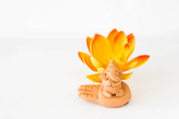 istock Lord Ganesha clay sculpture with flower on white background 1412651070