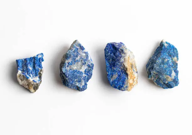 Raw Lazurite Mineral Stones on white Background. Tectosilicate. Blue Lapis lazuli specimens