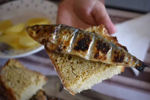Grilled sardine on a piece of cornbread