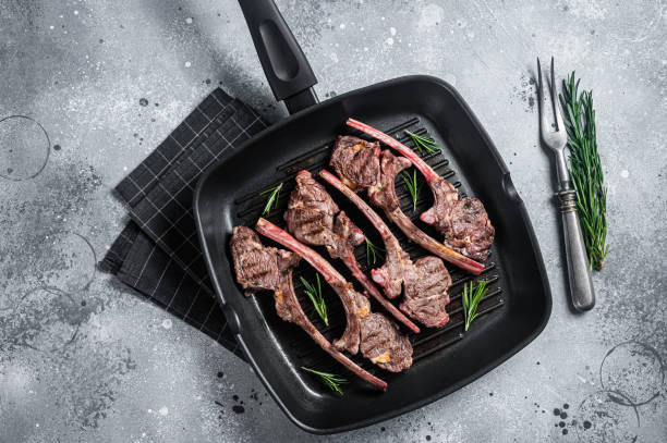istock Fried on a grill skillet lamb cutlet steak, mutton rib chop. Gray background. Top view 1412651771