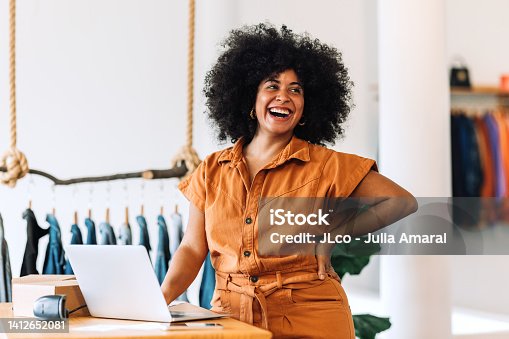 istock Ethnic small business owner smiling cheerfully in her shop 1412652081