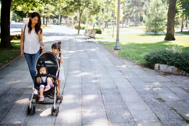 istock Single mom walking in park with baby stroller 1412653069