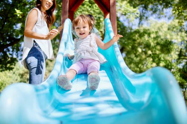 istock Little toddler girl having fun while sliding 1412653335
