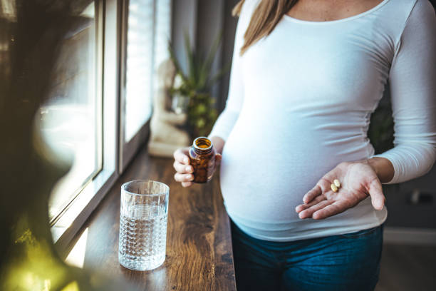 mulher feliz segura copo de água, toma vitamina de remédio diário - ácido fólico - fotografias e filmes do acervo