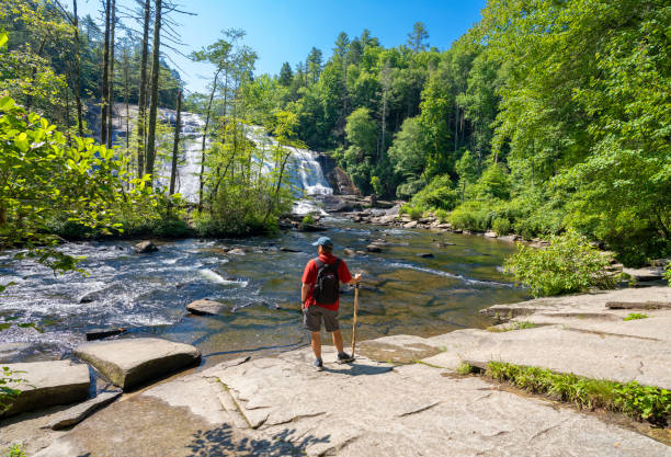 istock Man standing by the river relaxing on hiking trip. 1412655490
