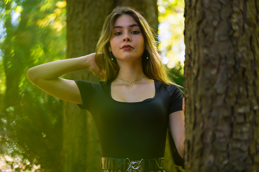 Portrait of a young woman next to a tree in nature in a natural park