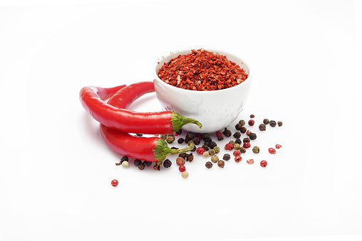 Set with red hot chili peppers and flakes on white background