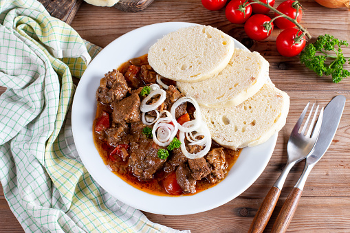 Fine Meat - Beef Goulash in a with Red Pepper on wooden table. Top view