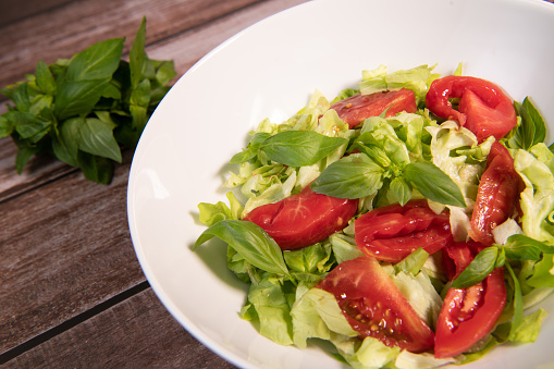 Green vegan salad, tomato and basilic from green leaves mix and vegetables, High quality photo