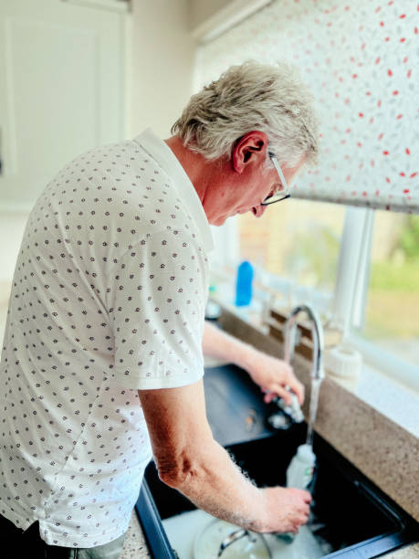istock Senior man washing the dishes in kitchen 1412658865