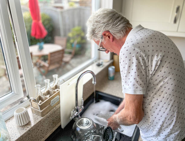 istock Senior man washing the dishes in kitchen 1412658873