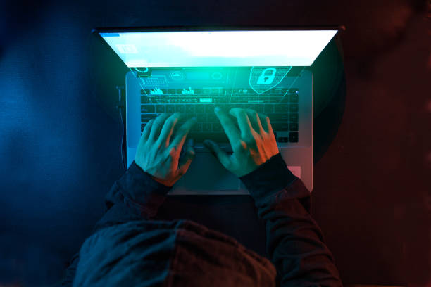 Overhead hacker in the hood working with futuristic laptop stock photo