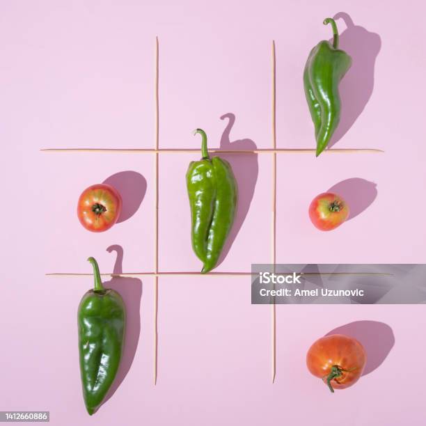 Healthy Food Creative Minimal Concept Vegetable X Ox Game With Three Organic Peppers And Three Tomatoes On A Pastel Pink Color Background And Wooden Sticks Frame Flat Lay Design Stock Photo - Download Image Now