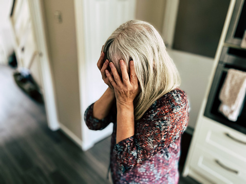 Portrait of an upset woman with her head in her hands. Room for copy space.