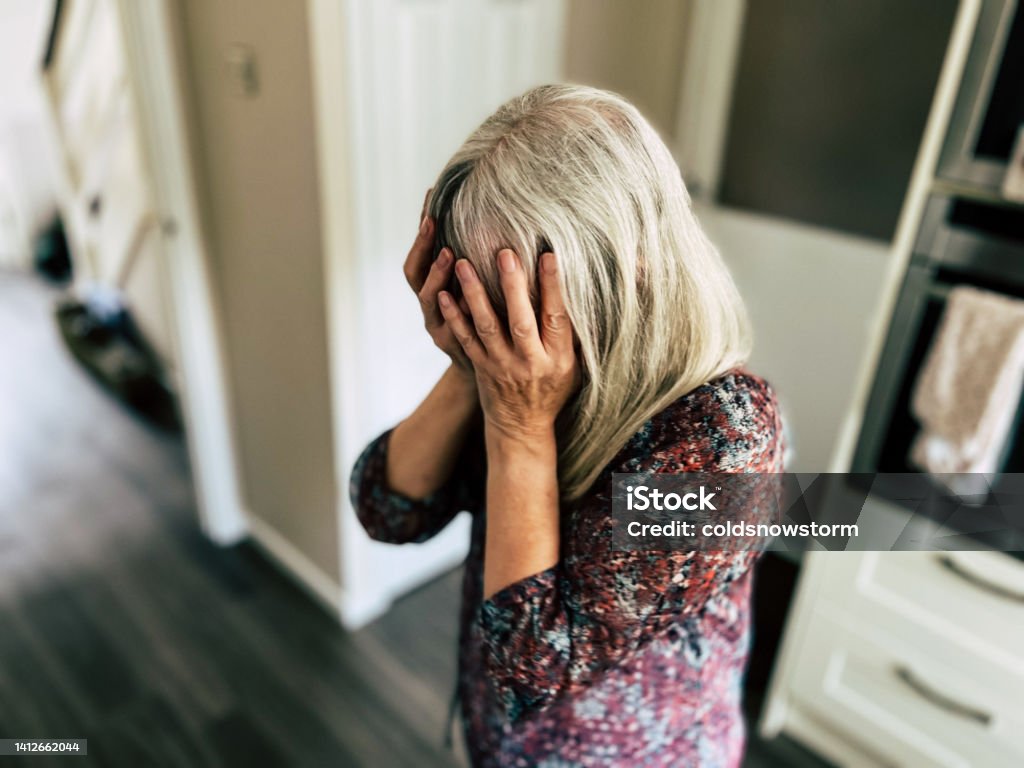 Depressed woman with head in hands Portrait of an upset woman with her head in her hands. Room for copy space. Senior Adult Stock Photo