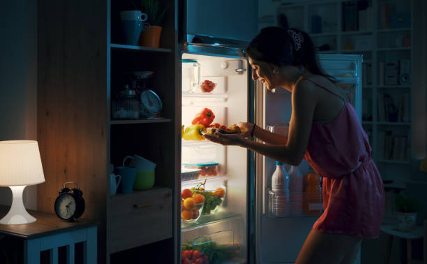 istock Hungry woman eating sweets at night 1412665074