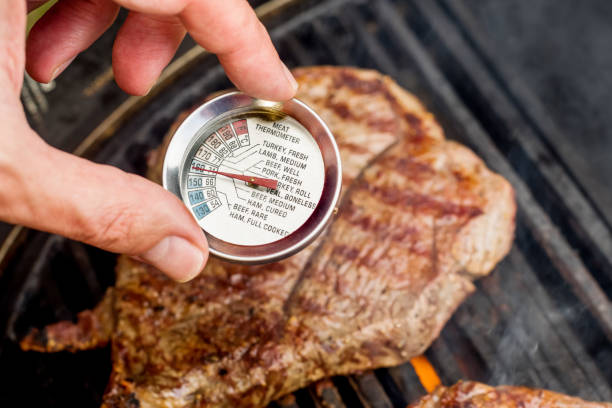 Beef blade steak grilling on barbecue grill plate with meat thermometer. Backyard BBQ grill cooking. Beef blade steak grilling on barbecue grill plate with meat thermometer. Backyard BBQ grill cooking meat. blade roast stock pictures, royalty-free photos & images