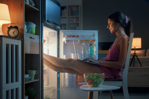 istock Woman cooling herself in front of the open fridge 1412665328