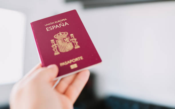 рука с испанским паспортом. - airport security people traveling airport security system стоковые фото и изображения