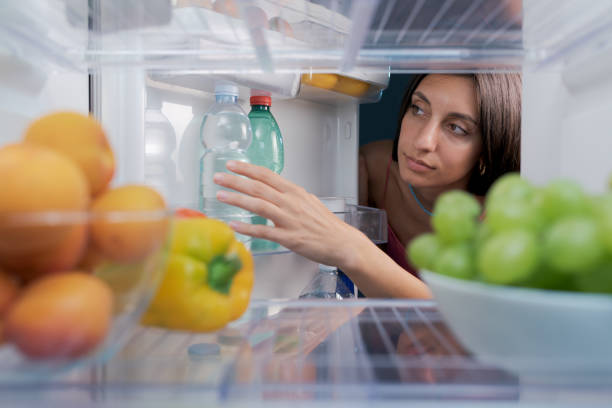 istock Woman taking a water bottle in the fridge 1412665702