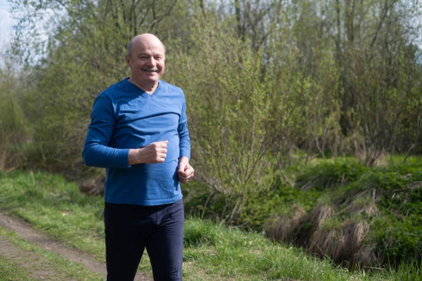 istock Active senior man is jogging in park. Healthy retirement lifestyle. 1412665764