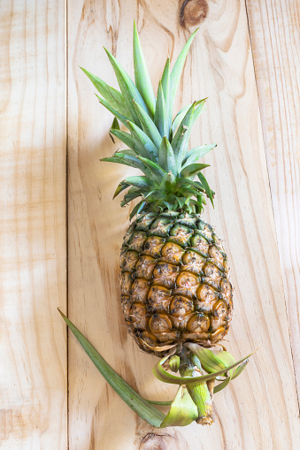 Pineapple on wood background, top view, healthy fruit food concept.
