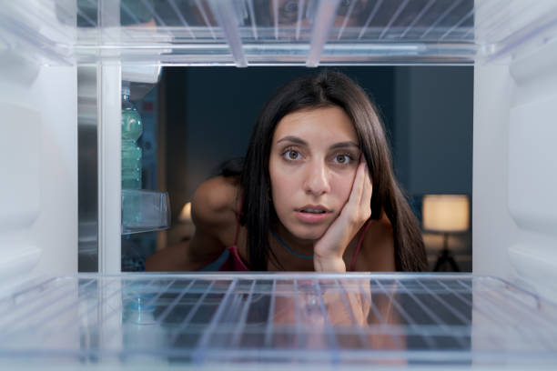 istock Shocked woman looking in her empty fridge 1412666819