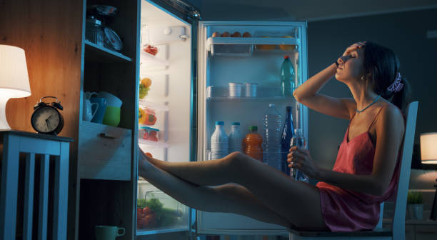 istock Woman cooling herself in front of the open fridge 1412666941