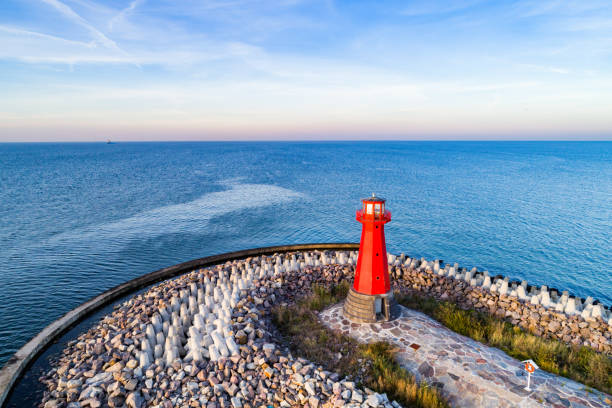 Red lighthouse on rocky harbor at sunsetGdansk, Poland