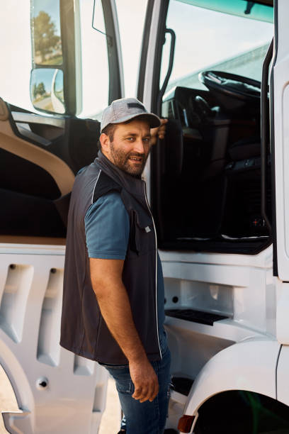 istock Professional driver entering in truck cabin and looking at camera. 1412671367
