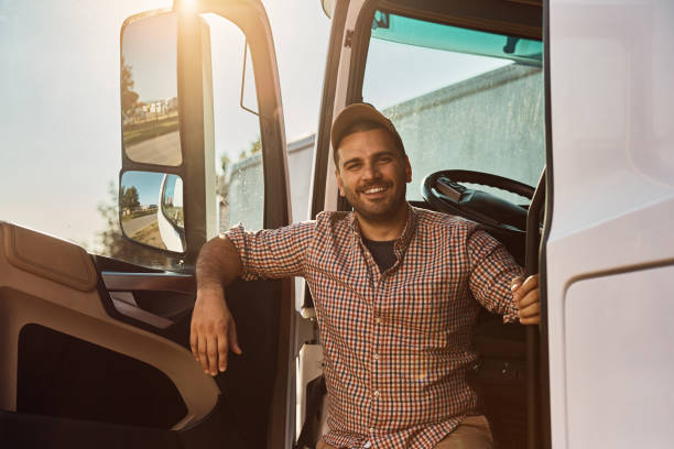 glücklicher fahrer in der lkw-kabine, der in die kamera schaut. - truck driver fotos stock-fotos und bilder