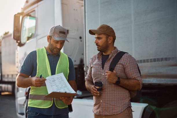 istock Truck driver and his dispatcher analyzing shipment list on parking lot. 1412673647