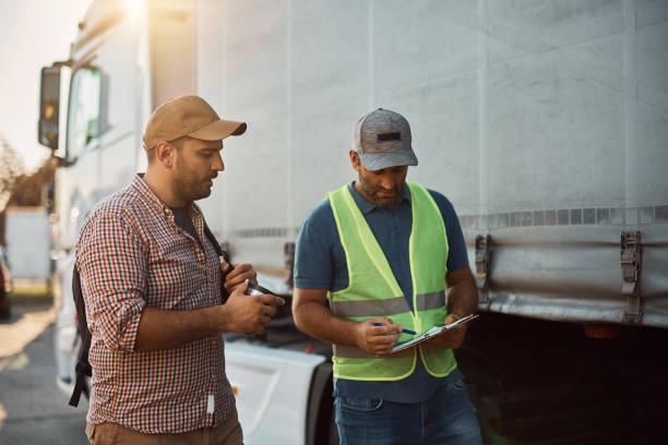 gestionnaire du transport de marchandises et chauffeur de camion qui passent en revue la liste de contrôle sur le stationnement. - construction checklist clipboard talking photos et images de collection