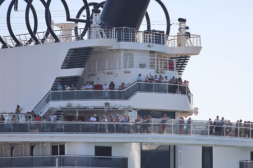 10th June, 2022 - Relaxed, happy and excited cruise ship passengers waving as they sail away from Barcelona Port in the 2018 MSC Seaview