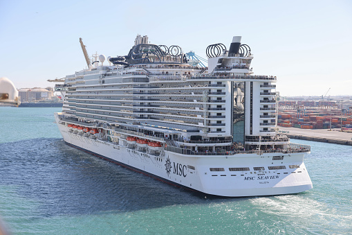 10th June, 2022 - Relaxed, happy and excited cruise ship passengers waving as they sail away from Barcelona Port in the 2018 MSC Seaview