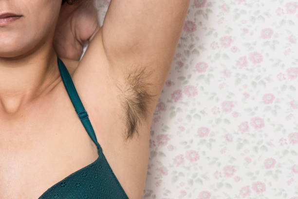 Hairy woman's armpit. Woman without waxing. Unplucked hair. Woman showing natural body hair without shaving. Hair growing in the armpit with the barazos without shaving. self-confident girl Hairy woman's armpit. Woman without waxing. Unplucked hair. Woman showing natural body hair without shaving. Hair growing in the armpit with the barazos without shaving. self-confident girl body hair stock pictures, royalty-free photos & images