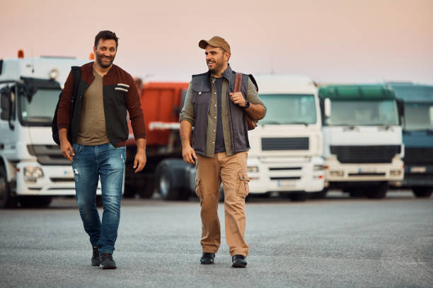 istock Happy truck drivers talking while walking on parking lot. 1412677681