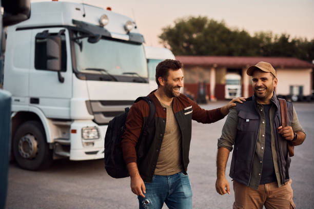 Cheerful truck drivers having fun on parking lot.