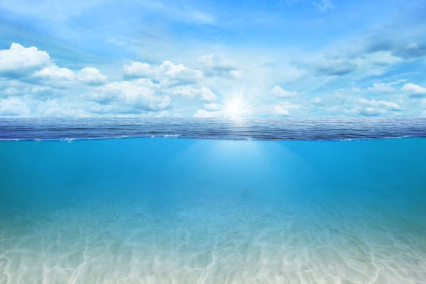 istock BLUE UNDER WATER waves and bubbles. Beautiful white clouds on blue sky over calm sea with sunlight reflection, Tranquil sea harmony of calm water surface. Sunny sky and calm blue ocean. 1412678753