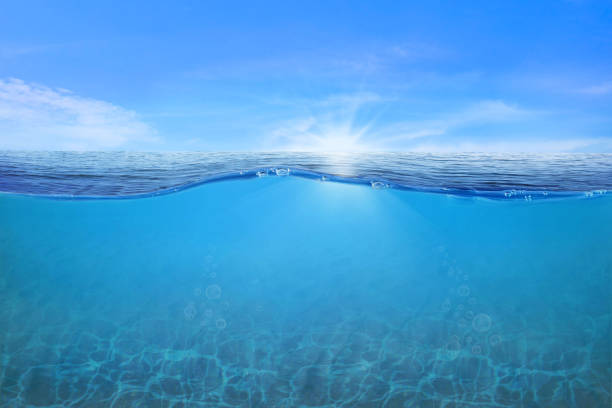 istock BLUE UNDER WATER waves and bubbles. Beautiful white clouds on blue sky over calm sea with sunlight reflection, Tranquil sea harmony of calm water surface. Sunny sky and calm blue ocean. 1412678780
