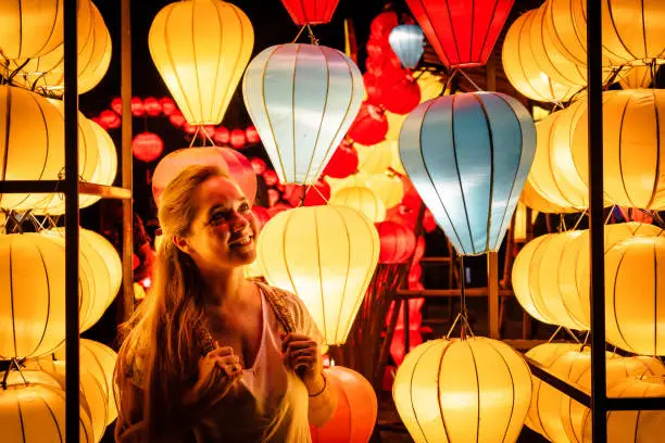 Photo of oung woman surrounded by lanterns in Hoi An old town