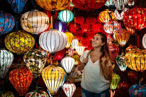 Young tourist surrounded by beautiful paper lanterns in Hoi An, Vietnam. Tourist dazzled by beautiful paper lanterns in Hoi An.