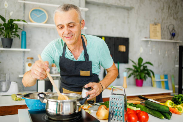 istock Happy man cooking at home 1412679611