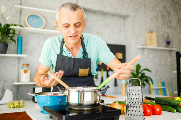 istock Man in kitchen smelling food 1412679658