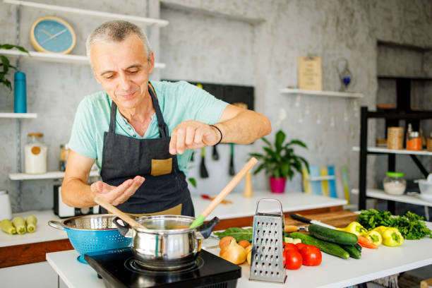 istock Mature man in kitchen cooking for his family 1412679663